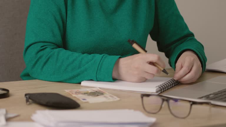 female hands writing budget numbers notes